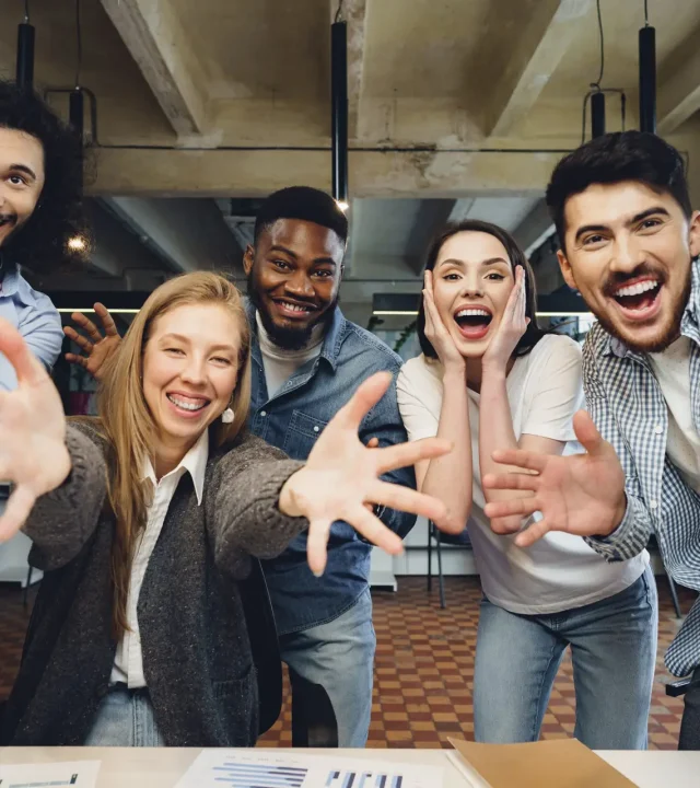 Happy overjoyed business team celebrate corporate victory in their office
